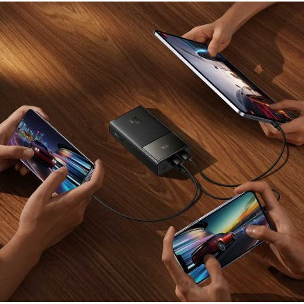 Black power bank in use charging multiple phones with connected cables