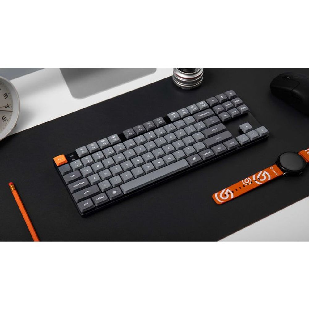 Black low-profile keyboard with gray keys and orange functional accents