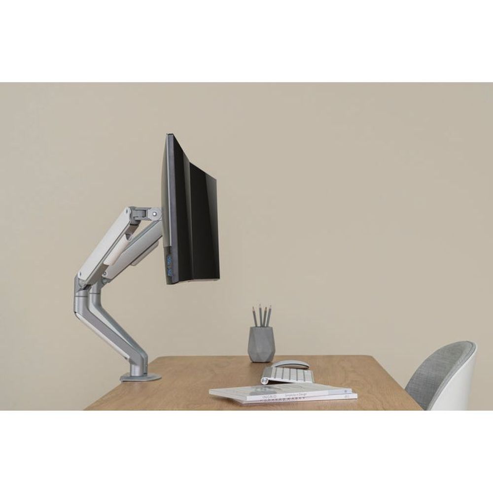 Dual monitor arm holding a monitor with a VESA plate, spring-assisted silver