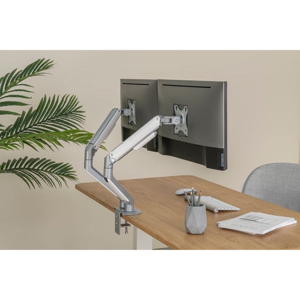 Dual monitor arm on desk with two VESA mounts, spring-assisted silver metal