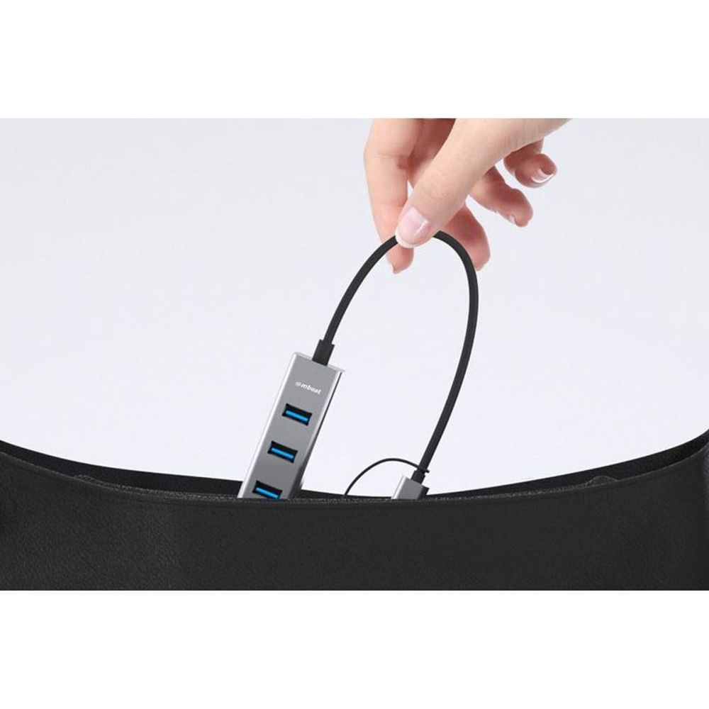 Space gray 4-port USB hub with USB-C converter, hand plugging in with blue ports