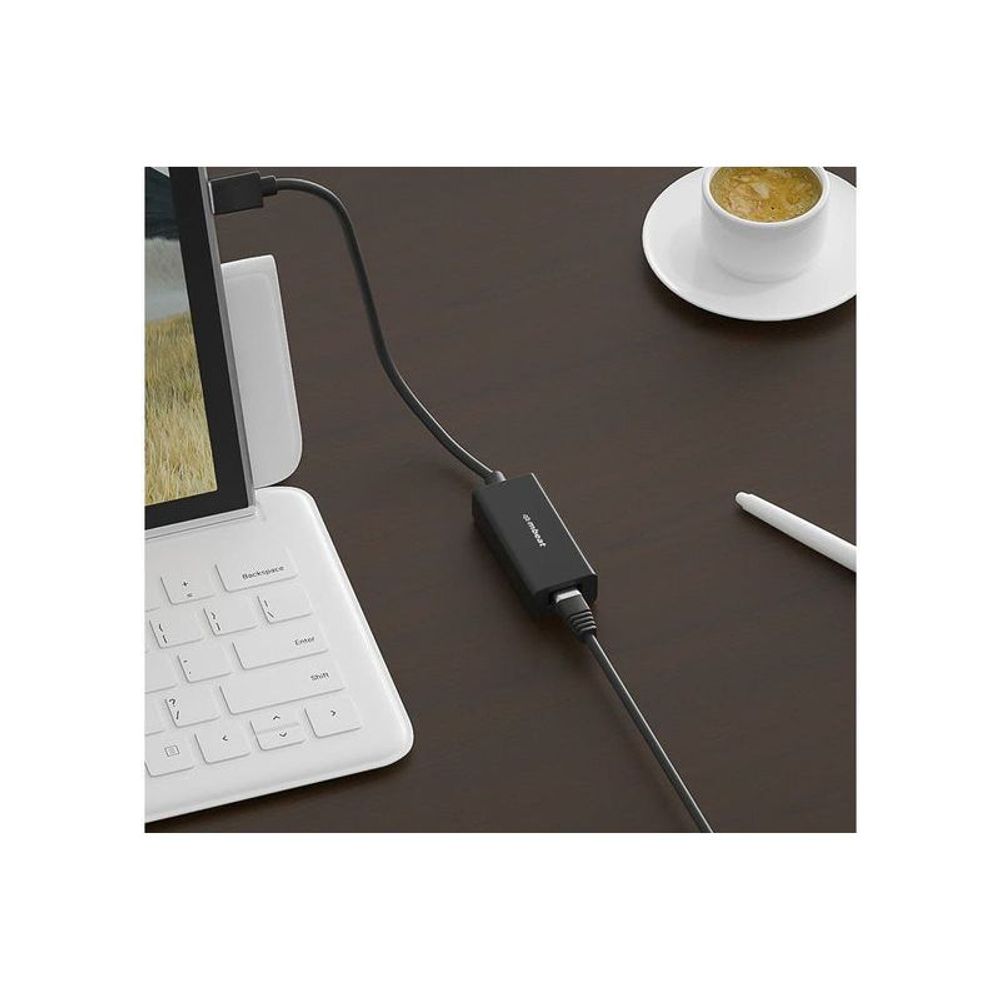 Black Ethernet adapter plugged into laptop USB port with RJ45 cable connection