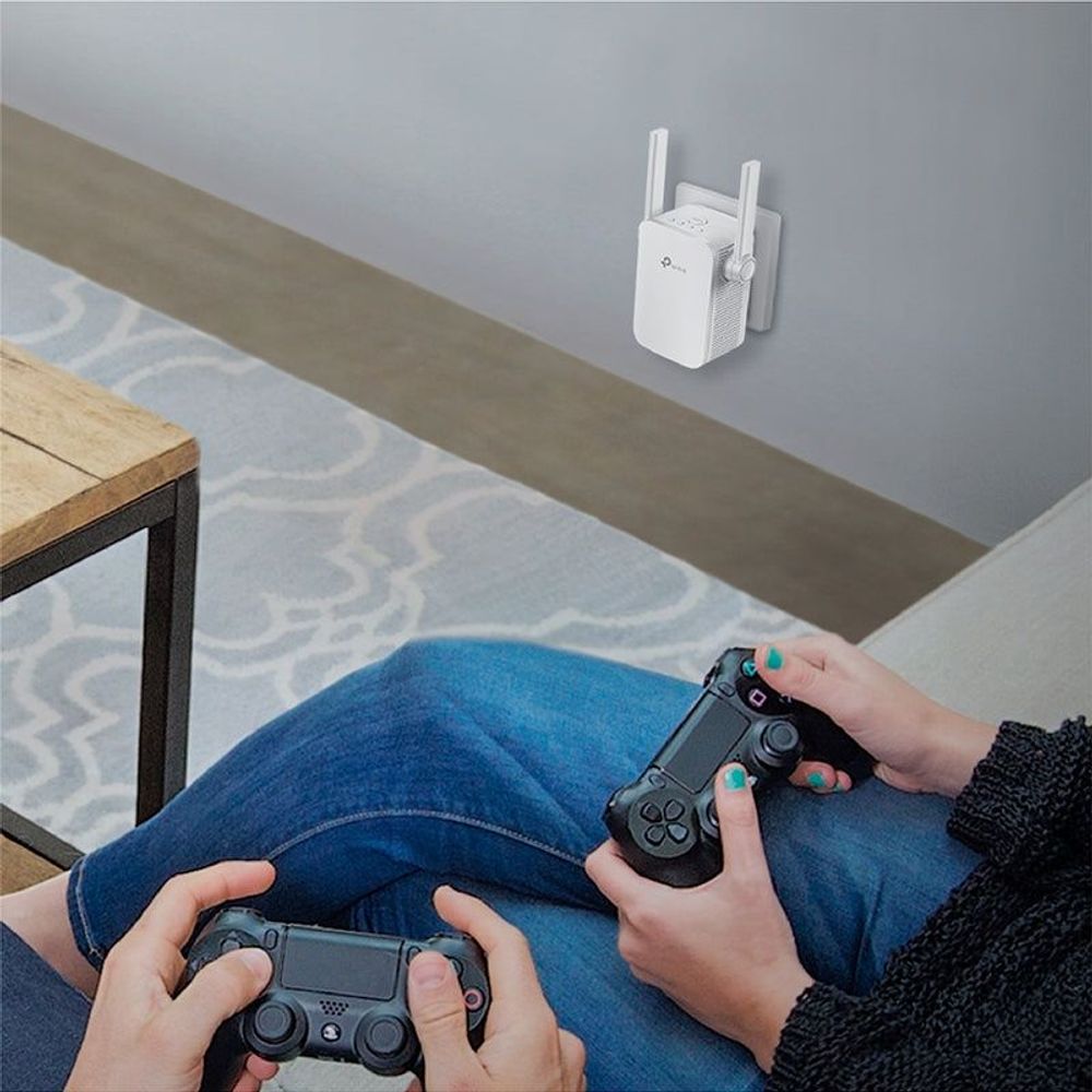 TP-Link wall-plug Wi‑Fi range extender on the wall with two upright antennas