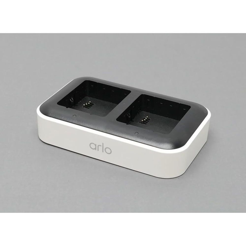 Arlo dual charging station with white base and two open bays, black interior.