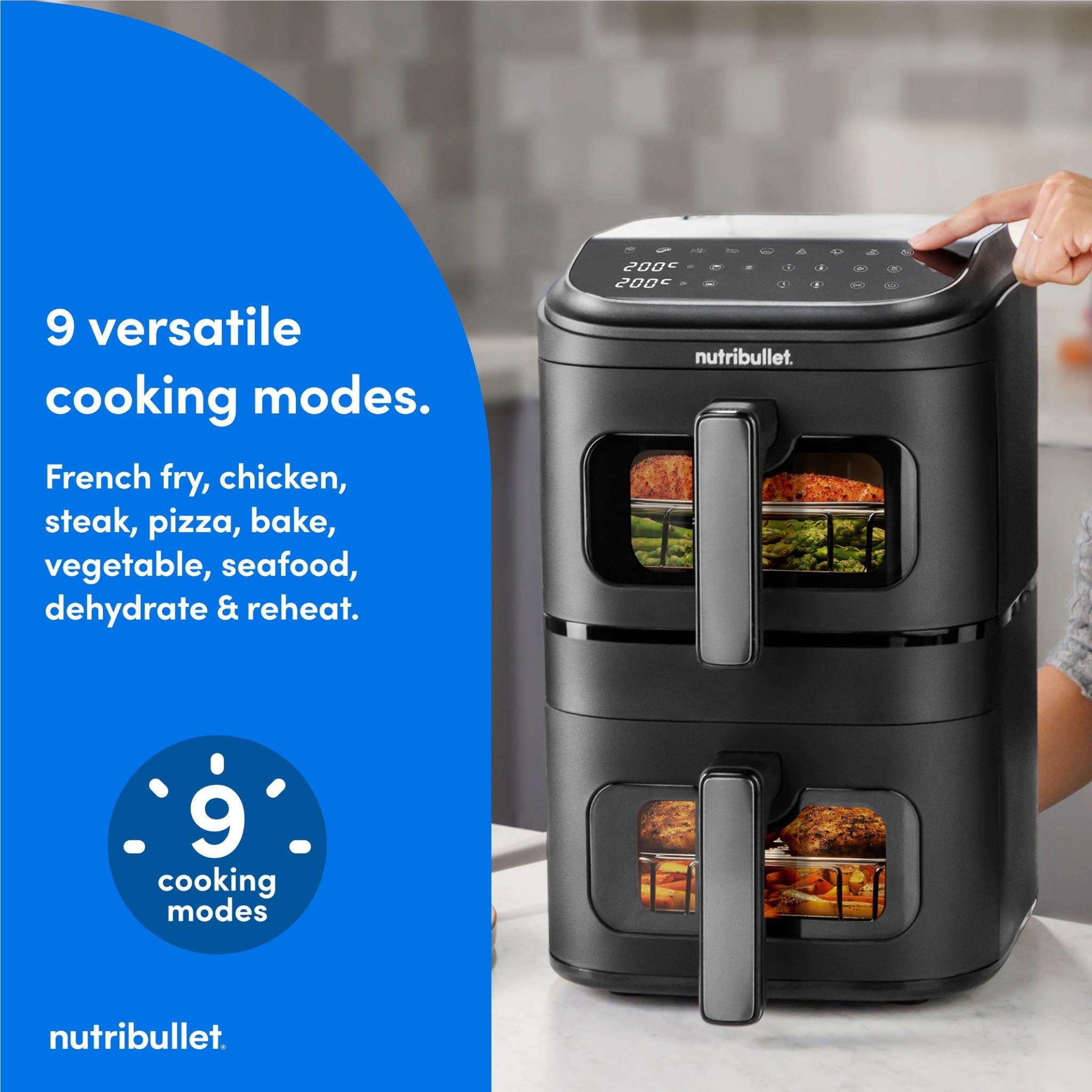Black stacked air fryer with two drawers and hand pressing down on top control panel